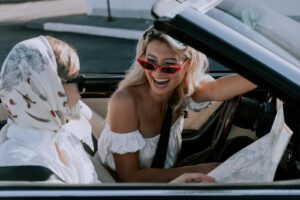 Woman in White Off Shoulder Top Wearing Red Framed Eyeglasses