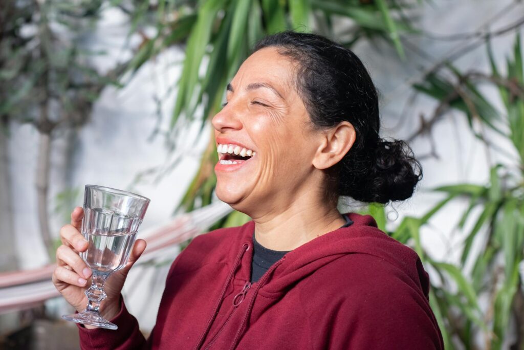 Photo of a Woman in a Red Hoodie Laughing