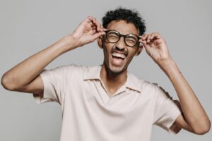 Man Holding Eyeglasses While Laughing