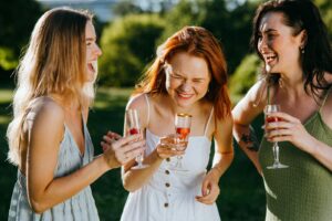 Women Holding Wine Glasses Smiling