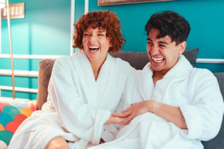 Happy Couple Wearing Bathrobes and Sitting on a Sofa