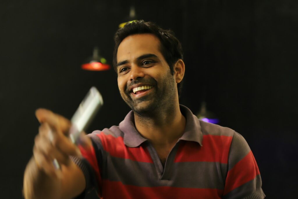 man in red and black v neck shirt holding white cigarette stick