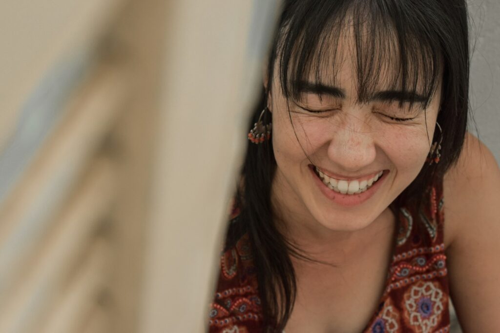 woman in red and white floral shirt smiling